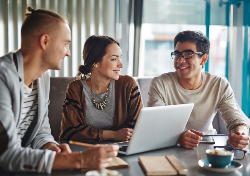 three-people-talking-around-laptop